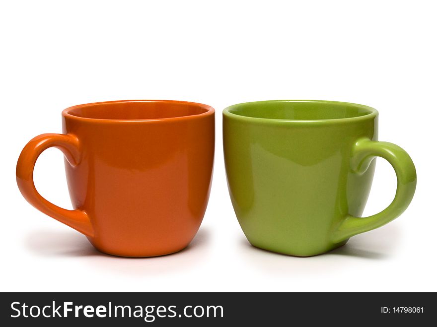 Two cups of different colour on a white background. It is isolated.