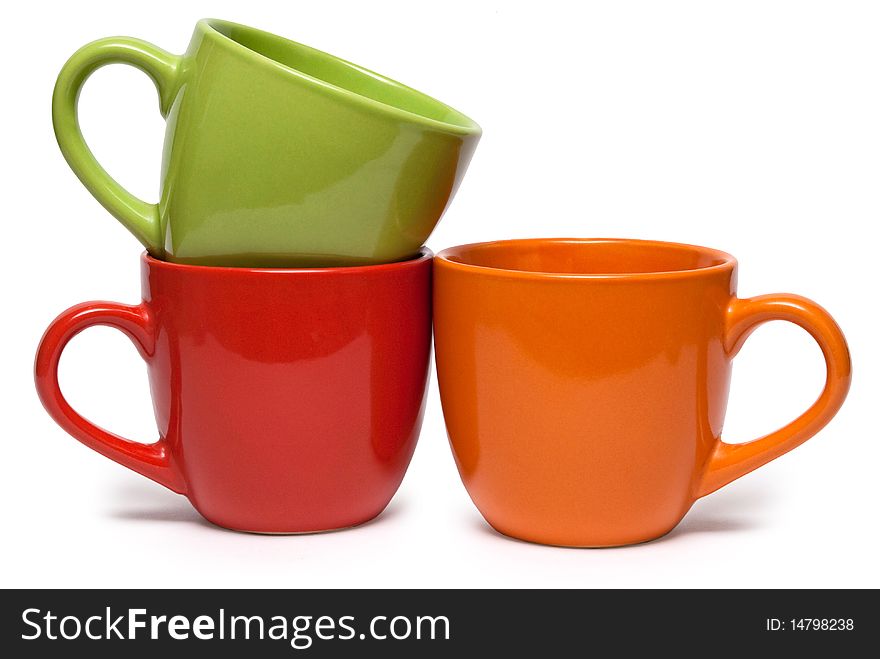 Three cups of various colour on a white background. It is isolated.