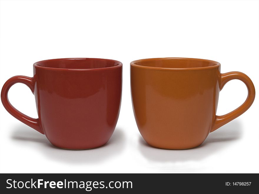 Two cups of different colour on a white background. It is isolated.