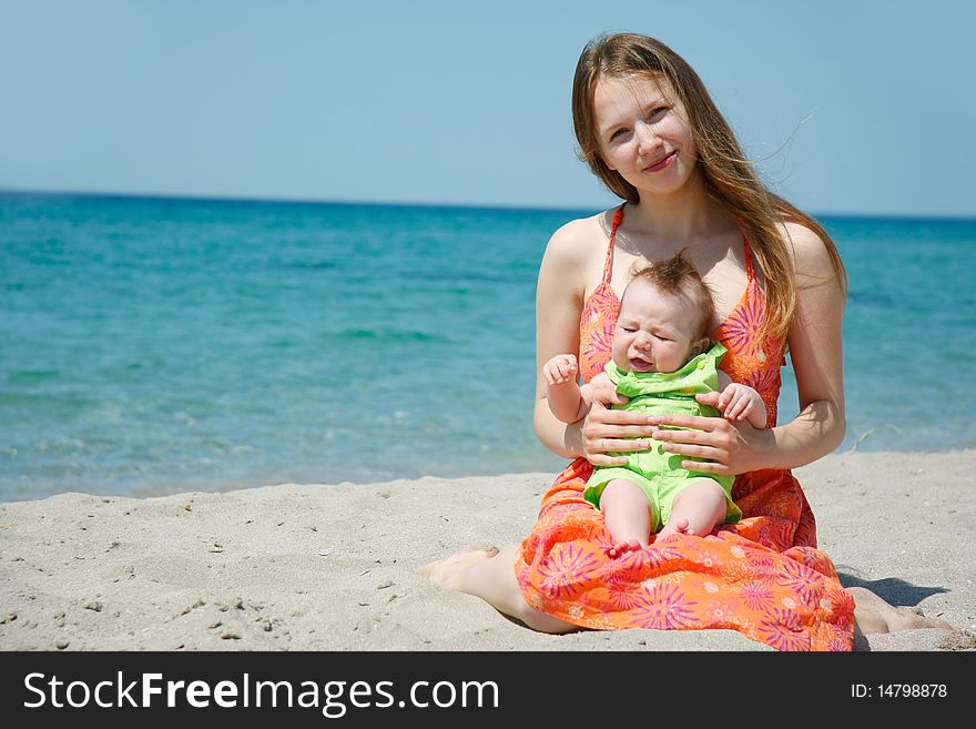 Young mother and baby on beach