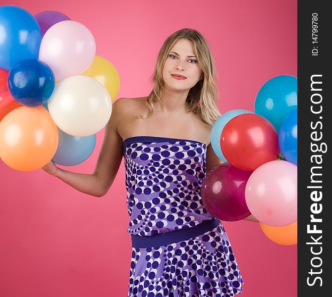 Pretty woman with colorful balloons on pink background. Pretty woman with colorful balloons on pink background