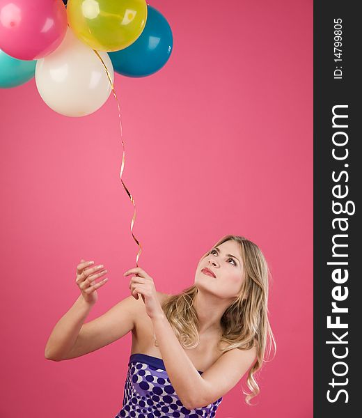 Pretty woman with colorful balloons on pink background. Pretty woman with colorful balloons on pink background