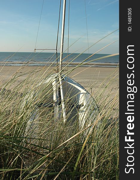 Deserted sailing boat on an empty beach, far from the sea. Deserted sailing boat on an empty beach, far from the sea.