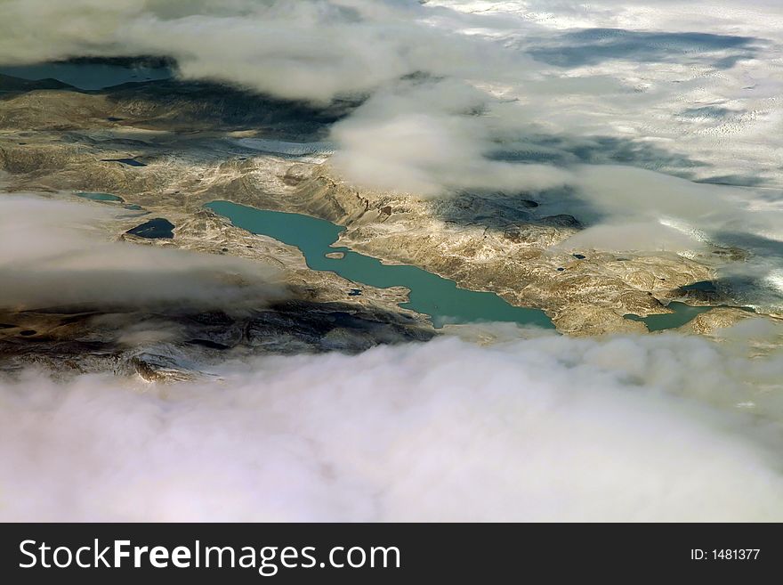 Green mountain lake surrounded by clouds