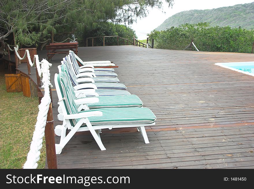Invitation to lie down and relax on deck chairs in tropical location