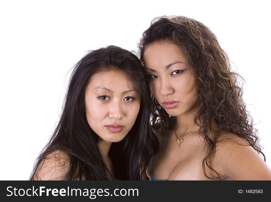 Two beautiful Asian-American women looking angry at the camera. Image isolated on white. Two beautiful Asian-American women looking angry at the camera. Image isolated on white.