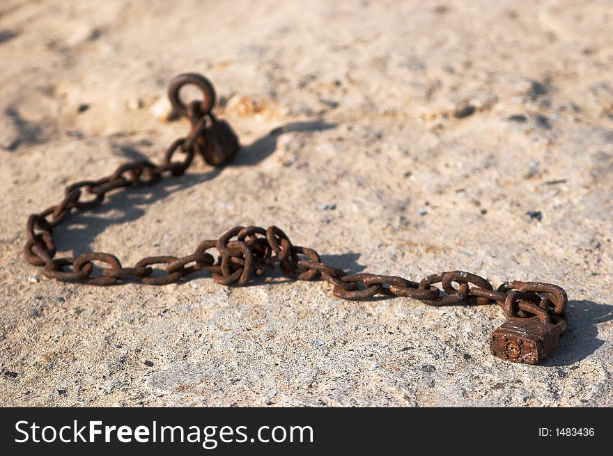 Rusted Chain and lock on concrete