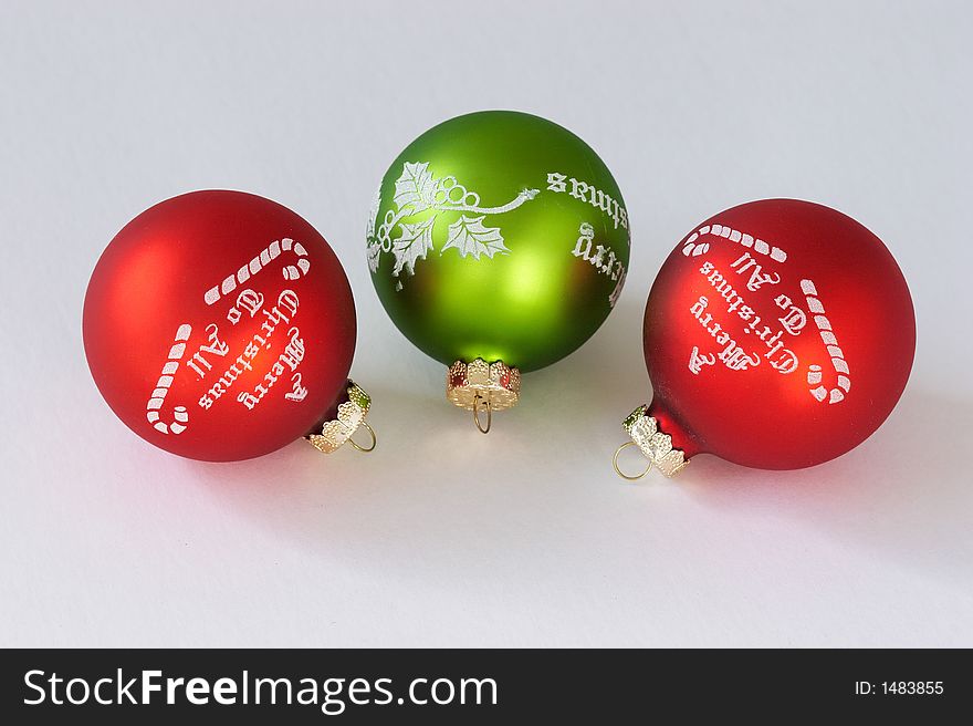 Three christmas balls. Two reds and one green.