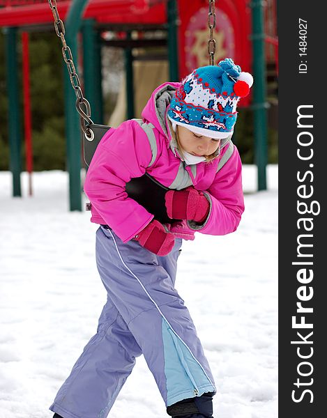 Little girl on playground at winter. Seneca Creek State Park, Maryland, USA