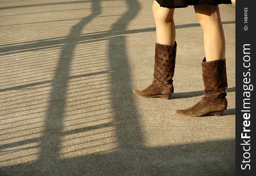 Girl standing next to shadow of fence