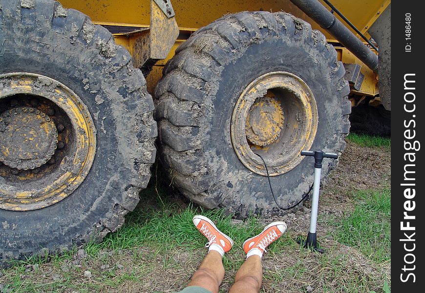 Filling a big tyre by hand with red boots. okt. 06. Filling a big tyre by hand with red boots. okt. 06