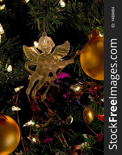 Crystal angel decoration hanging on a christmas tree. Illuminated in golden looking light. Crystal angel decoration hanging on a christmas tree. Illuminated in golden looking light.