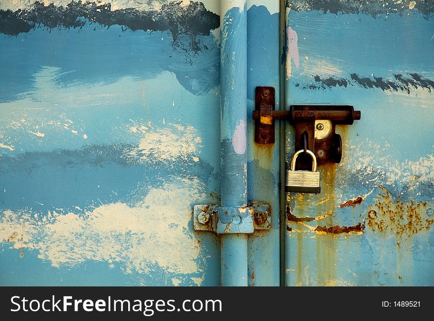Steel storage locker decorated and painted like blue sky with clouds.  Rusty bolt and padlock. Steel storage locker decorated and painted like blue sky with clouds.  Rusty bolt and padlock.