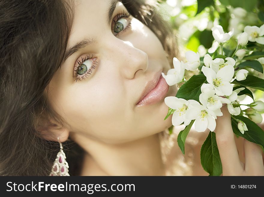 The image of a beautiful girl in the flowered garden