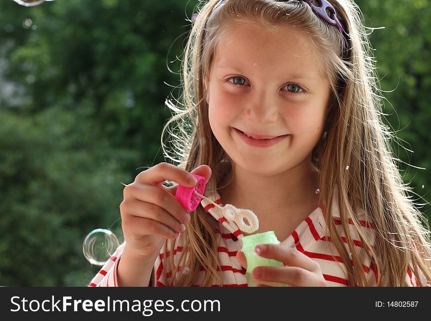 An image of a nice girl making bubbles. An image of a nice girl making bubbles