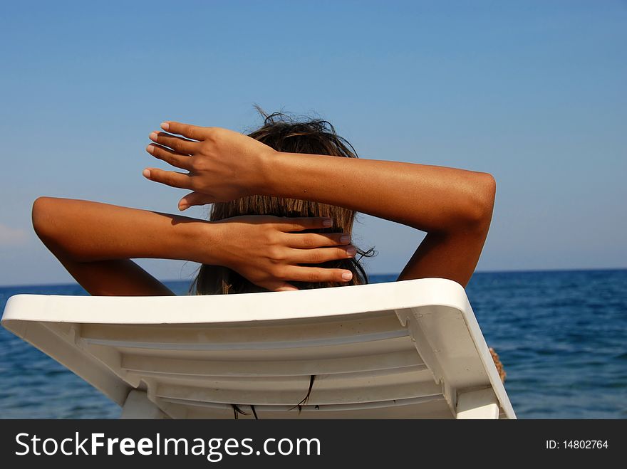 Young girl lying on beach looking at sea view. Young girl lying on beach looking at sea view