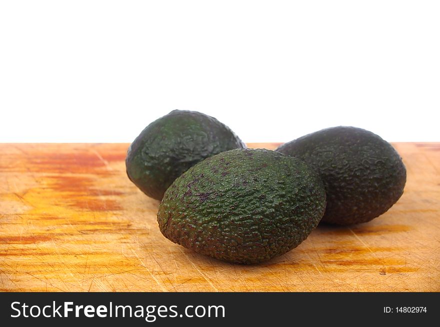 Whole avocado black skin variety over white isolated on board