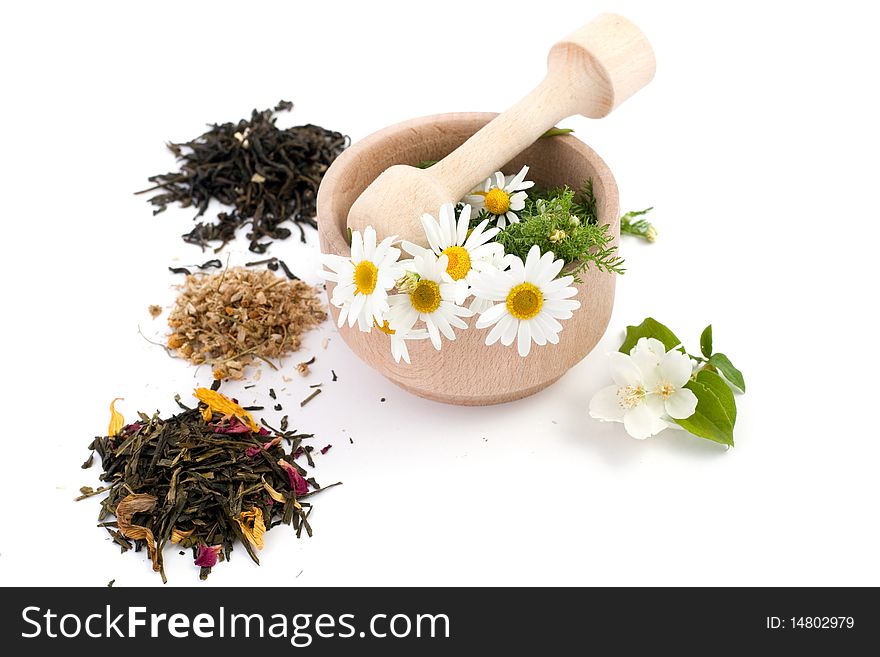 An image of wooden mortar with flowers and tea. An image of wooden mortar with flowers and tea