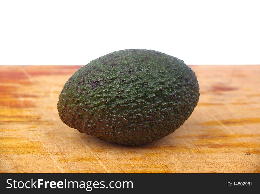 Whole avocado black skin variety over white isolated on board