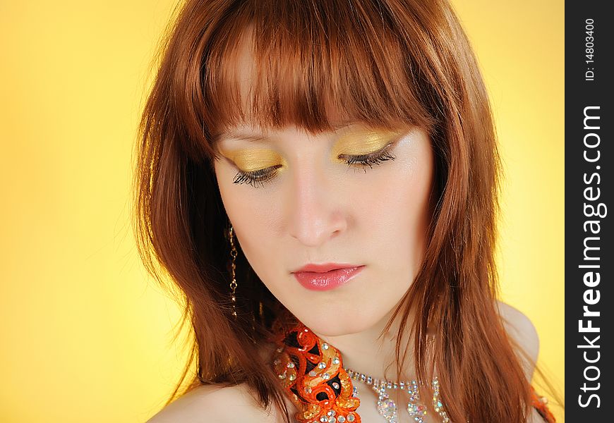 Beautiful woman face with golden arabic make-up. yellow background