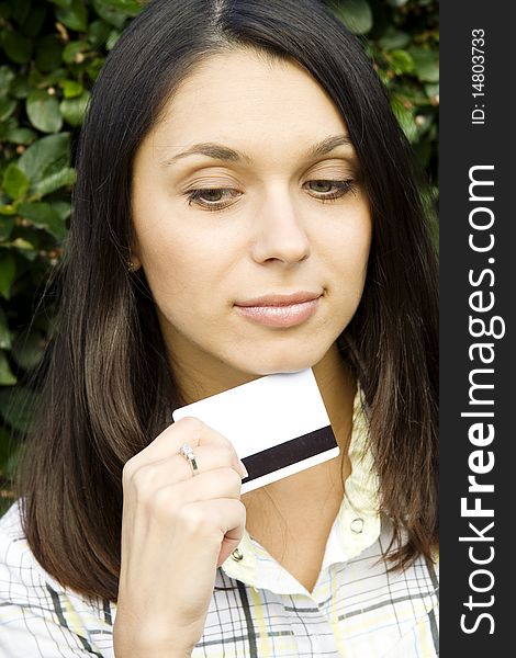 Young beautiful woman outdoors with a plastic credit card. Sign OK. Young beautiful woman outdoors with a plastic credit card. Sign OK