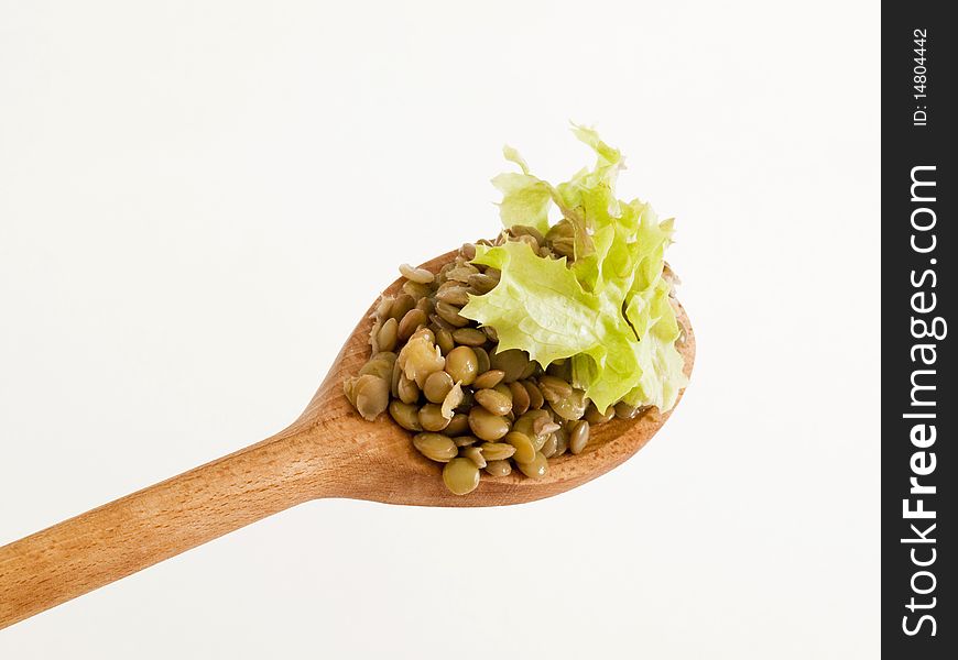 Cooked lentils on a wooden spoon - detail