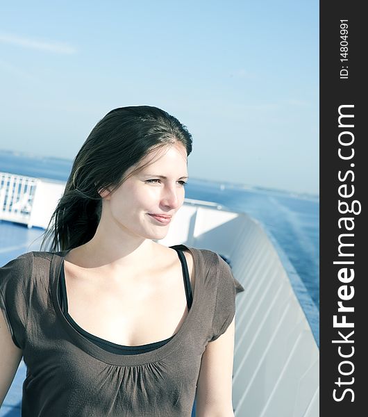 Woman on the upper deck of a cruise ship smiling. Woman on the upper deck of a cruise ship smiling