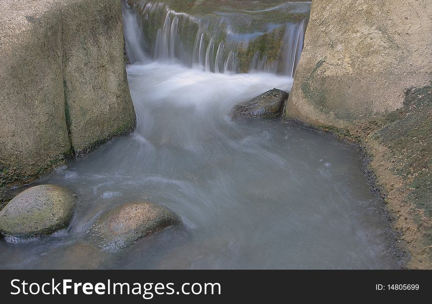 Stream of water flowing down river passing through rocks. Stream of water flowing down river passing through rocks.