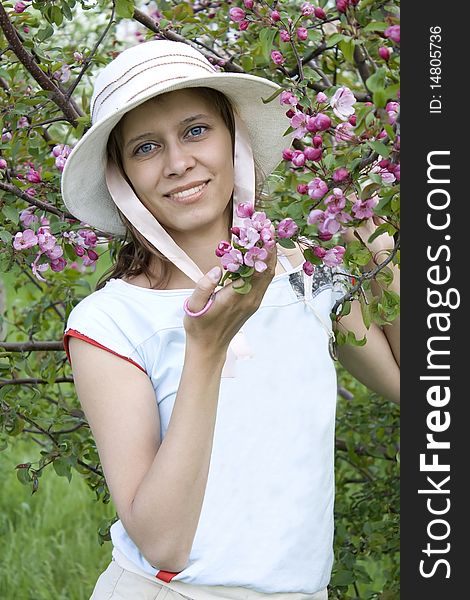 The young woman has control over a blossoming branch. The young woman has control over a blossoming branch