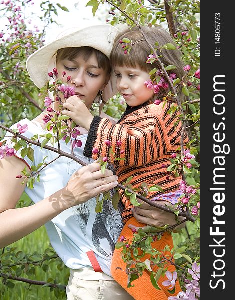 The girl allows to mum to smell a branch with colours. The girl allows to mum to smell a branch with colours