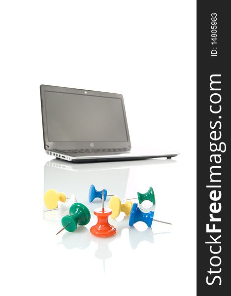 Several many-coloured thumbtacks and laptop over white background. Several many-coloured thumbtacks and laptop over white background