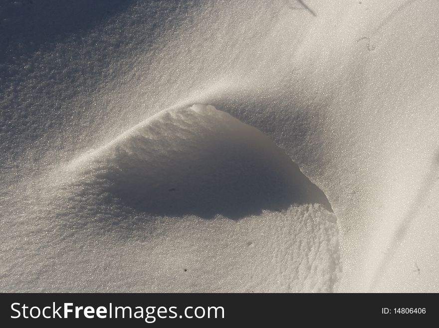 A small snow drift with a shadow.
