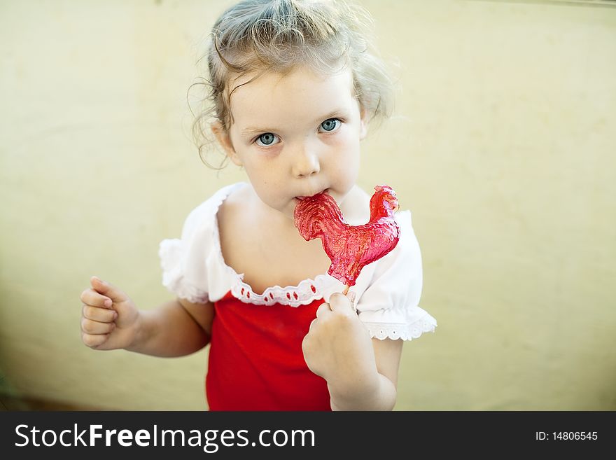 An image of a little girl with sweet red lollipop