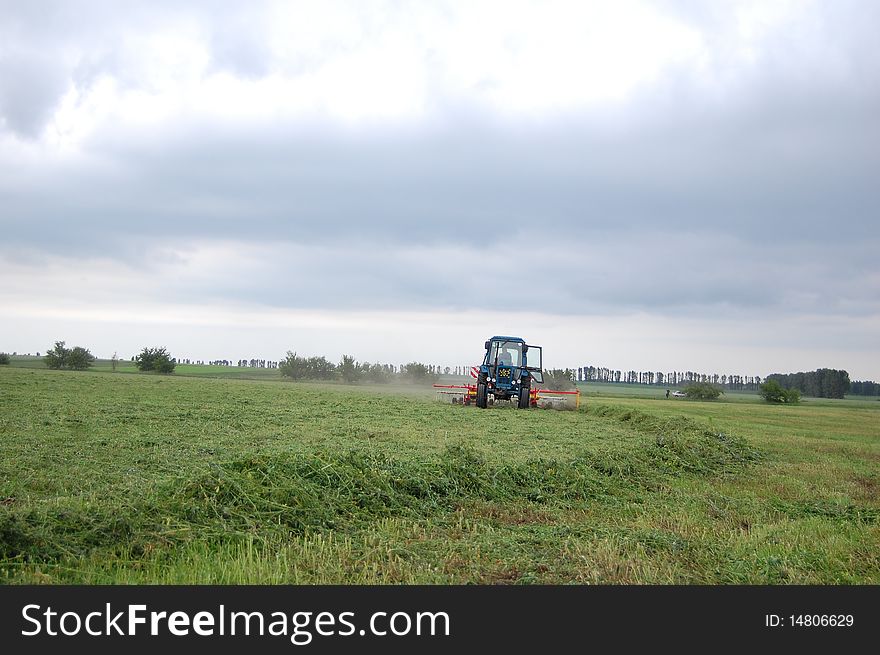 Tractor with rake make moving from grass. Tractor with rake make moving from grass