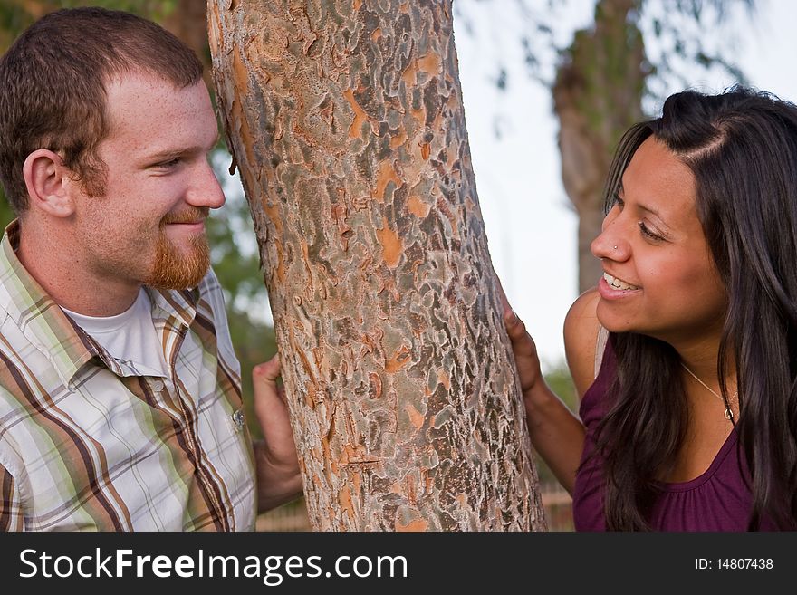 A young couple smiling together in the park. A young couple smiling together in the park.