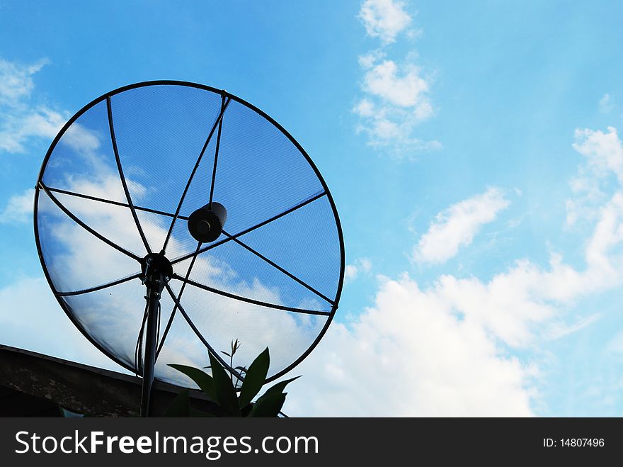 Satellite dish with a cloudy sky