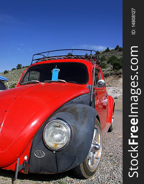 Red classic car against blue sky background