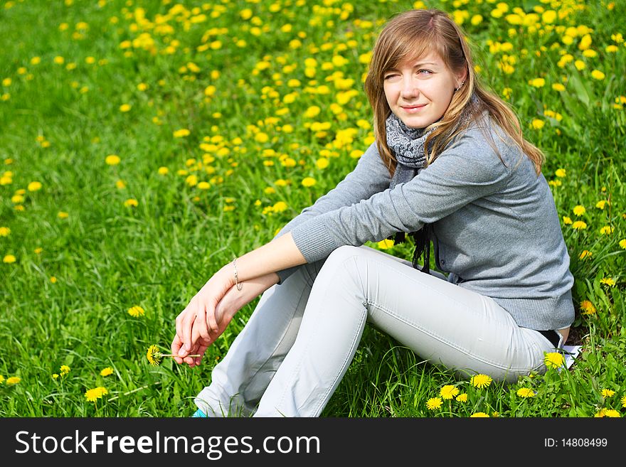 The girl sits on a grass