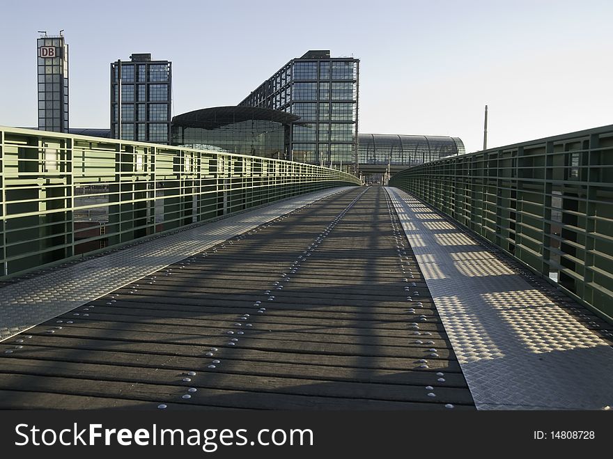 View along the pedestrian bridge across the River Spree towards the modern Central Railway station in Berlin early in the morning. View along the pedestrian bridge across the River Spree towards the modern Central Railway station in Berlin early in the morning