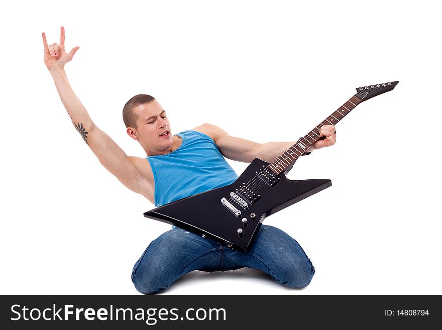 Attractive musician playing guitar on his knees and making a rock and roll gesture over white. Attractive musician playing guitar on his knees and making a rock and roll gesture over white
