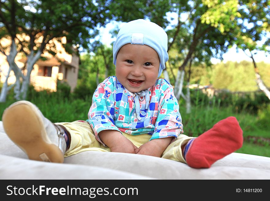 Funny baby boy in one boot outdoors. Funny baby boy in one boot outdoors