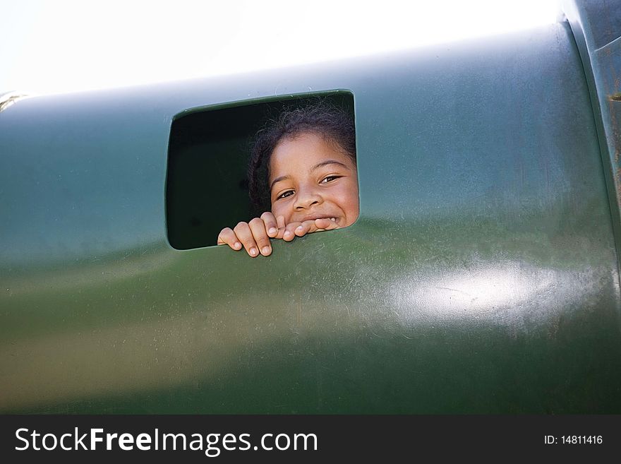 Little girl peeking out window at playground