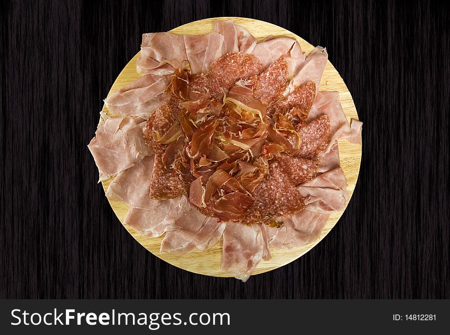 Slices of ham and salami in a dish. Slices of ham and salami in a dish