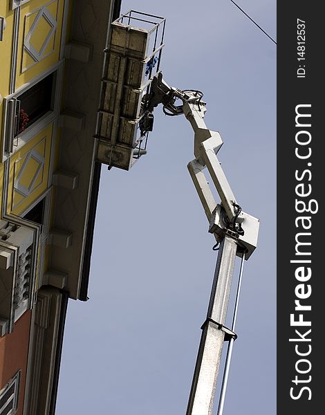 Workers restoring a building on a crane. Workers restoring a building on a crane