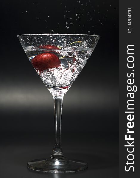 Cherry splashing into the cocktail glass. Cherry splashing into the cocktail glass.