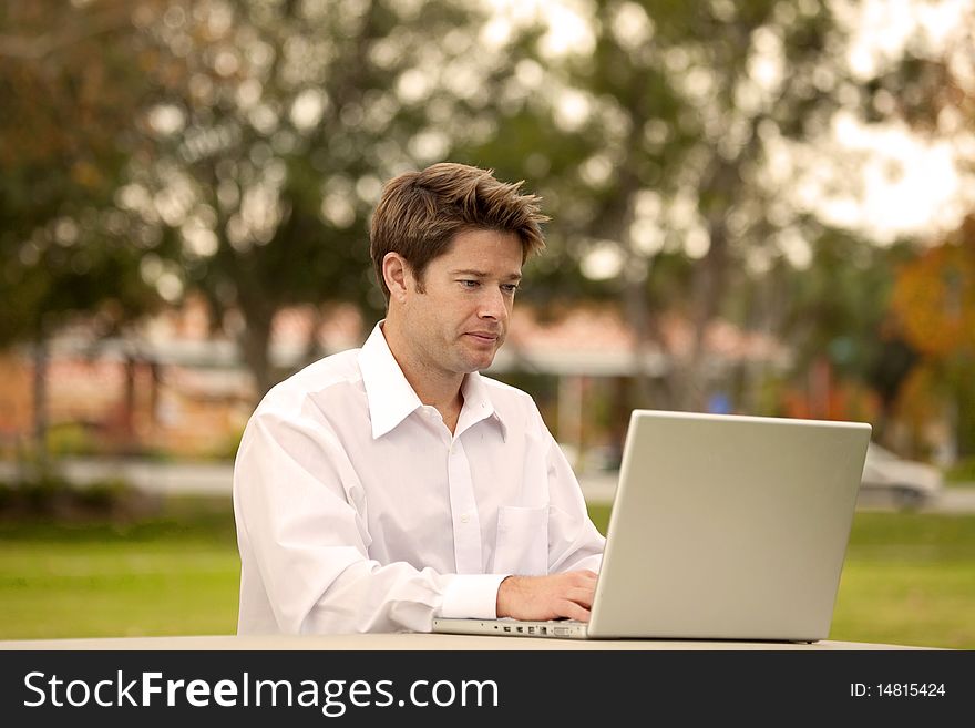 Man looking at his laptop outside. Man looking at his laptop outside