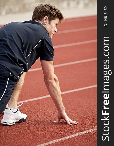 Man getting ready to run on a track. Man getting ready to run on a track