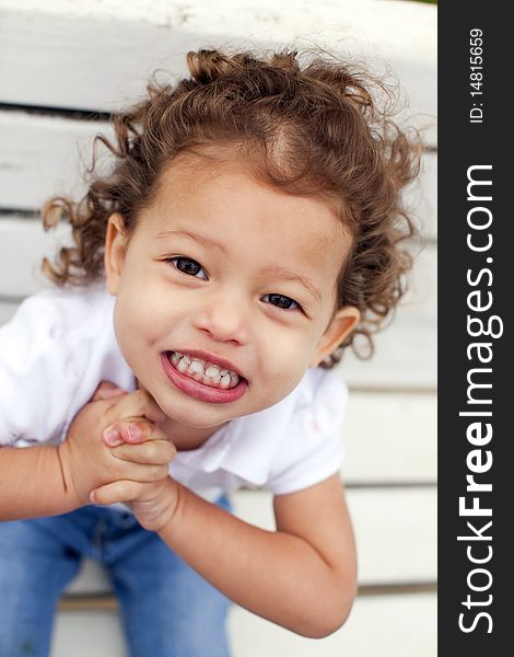 Portrait of a cute little girl on bench