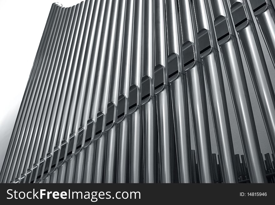 Modern steel organ pipes in a row descending. Modern steel organ pipes in a row descending