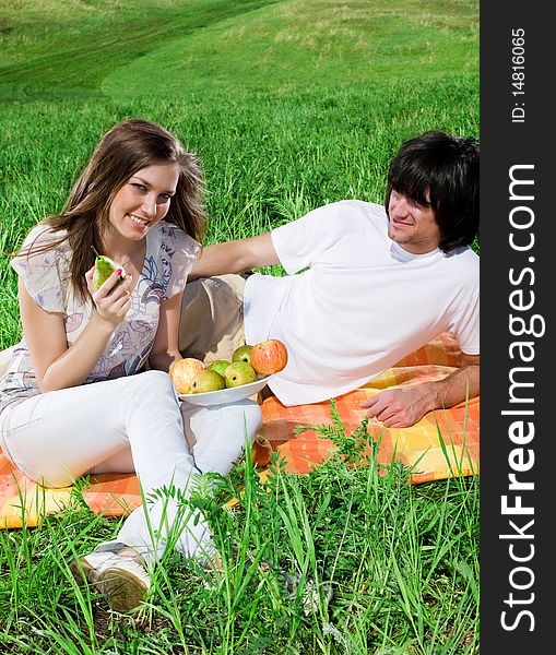 Girl with fruit and boy with smile on grass
